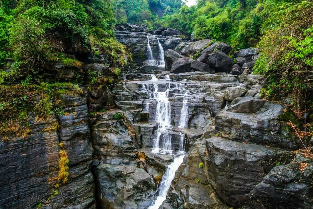 Waterfall cascading over rocky terraces in the forests of Meghalaya